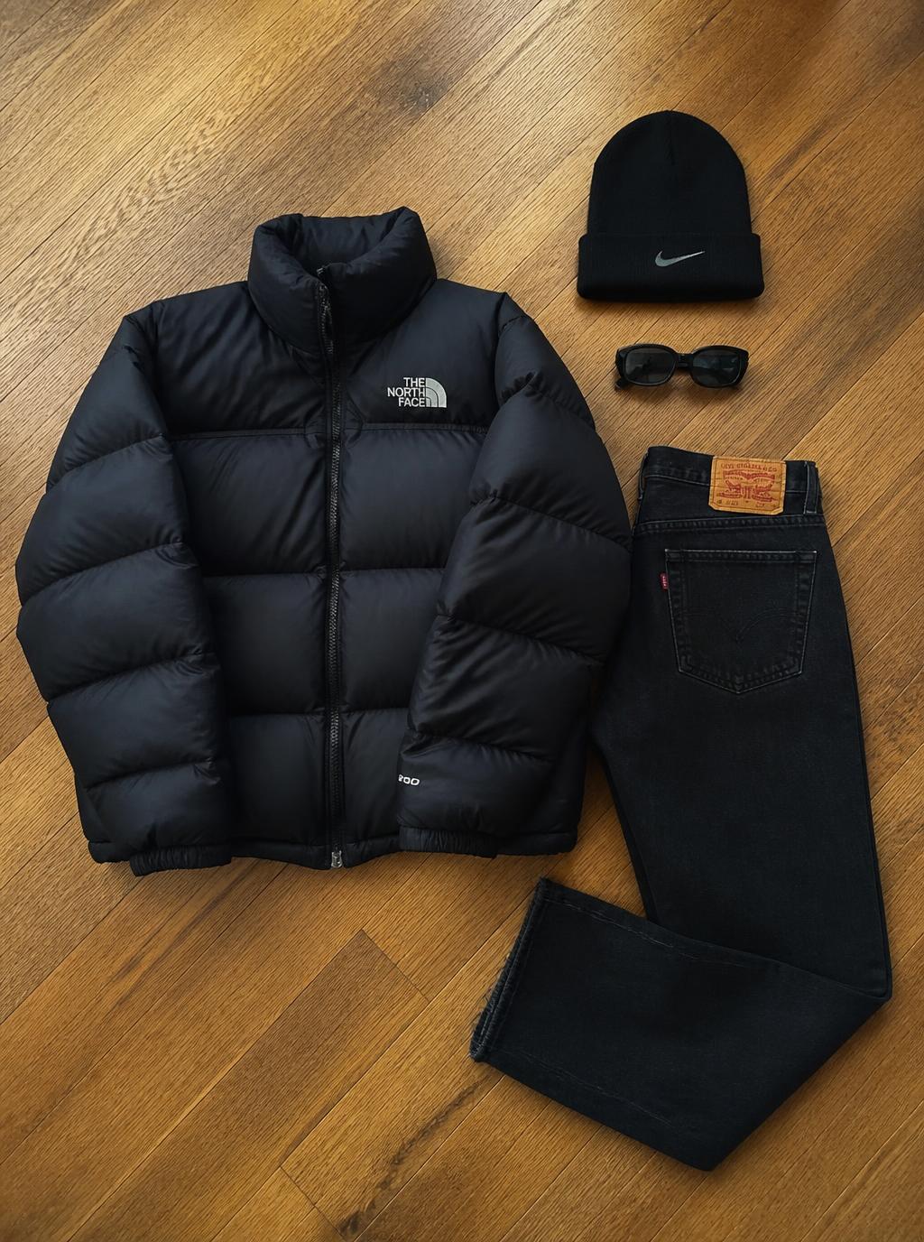 Black puffer jacket with black jeans, beanie and sunglasses